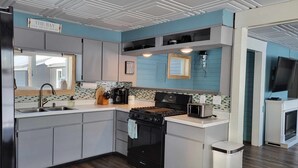 A modern kitchen with a gas stove, sink, and a coffee maker.