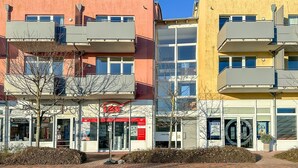 Um edifício com vários andares, varandas e fachada comercial.