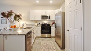 A modern kitchen with white cabinets, stainless steel appliances, and a granite countertop. - ~Weekly 15% OFF~ Modern Charm w/ Luxury Beds, Fireplace, Workspace (Luray)