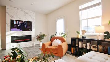 Smart-tv, een open haard, boeken en een computerscherm