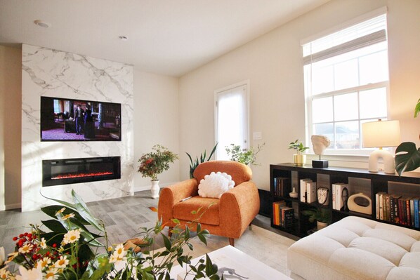 Una Smart TV, una chimenea, libros, una pantalla de ordenador