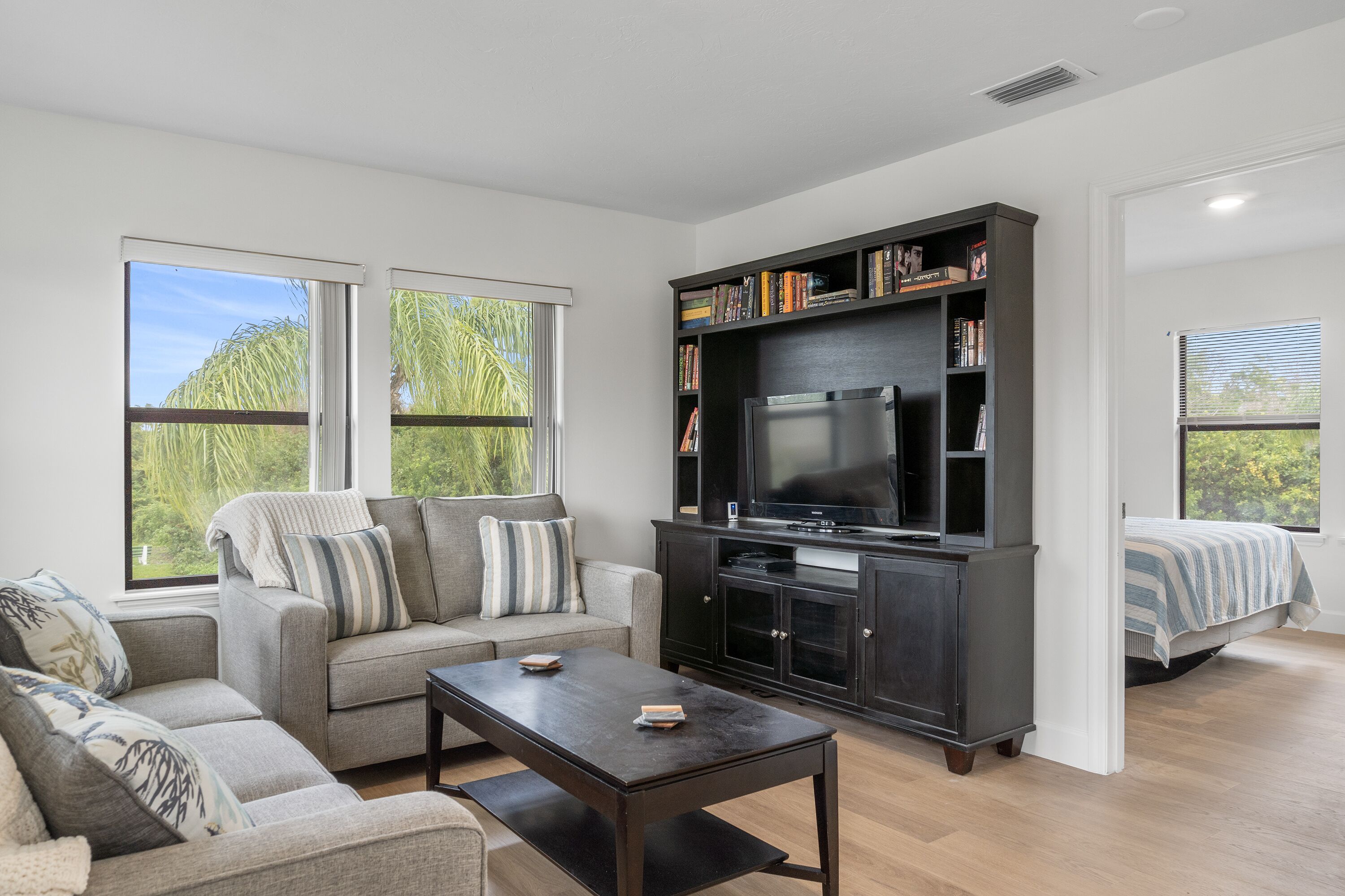 A modern living room with a sofa, coffee table, TV, and bookshelf.