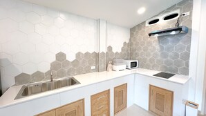 A modern kitchen with a stainless steel sink, a microwave, and wooden cabinets. - 48 House - Patong (Tambon Patong)