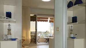 Une cuisine compacte avec un coin repas, un balcon doté d’une table et de chaises, et une vue sur l’extérieur.