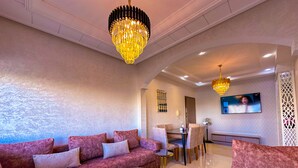 A modern living room with a plush pink sofa set, a round coffee table, and a chandelier. - Luxury & Clean close to the Sea (Tangier)