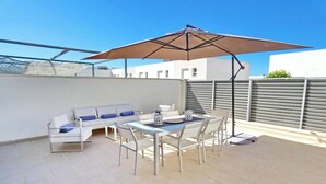 A rooftop terrace with a dining table, chairs, a sofa, and an umbrella. - El Grullo, with community pool. (Conil de la Fra.)