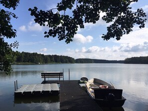 A calm lake with a dock, a bench, and a small boat. - Apartment 'Ferienwohnung Himmelpfort' with Shared Terrace, Shared Garden and Wi-Fi (Himmelpfort)