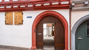 An arched entrance with wooden doors and a green door to the right. - Half-Timbered Apartment 'Fachwerk' with Wi-Fi (Neustadt an der Weinstrasse)