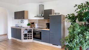 Uma cozinha moderna com forno embutido, máquina de café e pia.