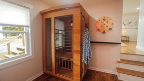 Un armario de madera con puerta de cristal, un reloj de pared redondo y una escalera.