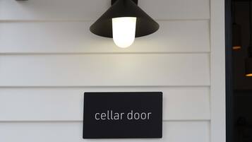 En vægmonteret lampe over et skilt med teksten 'cellar door'.