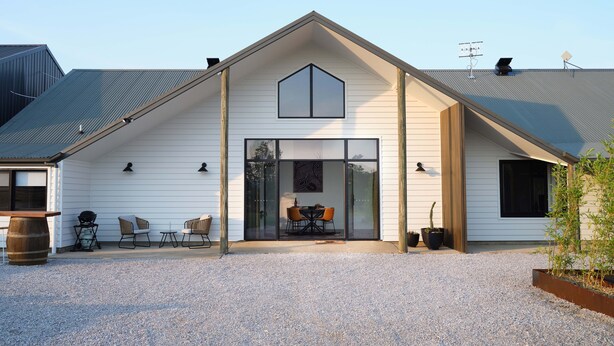 A modern house with a sloped roof, large windows, and a gravel driveway. - Shawwood Estate (Bombira)