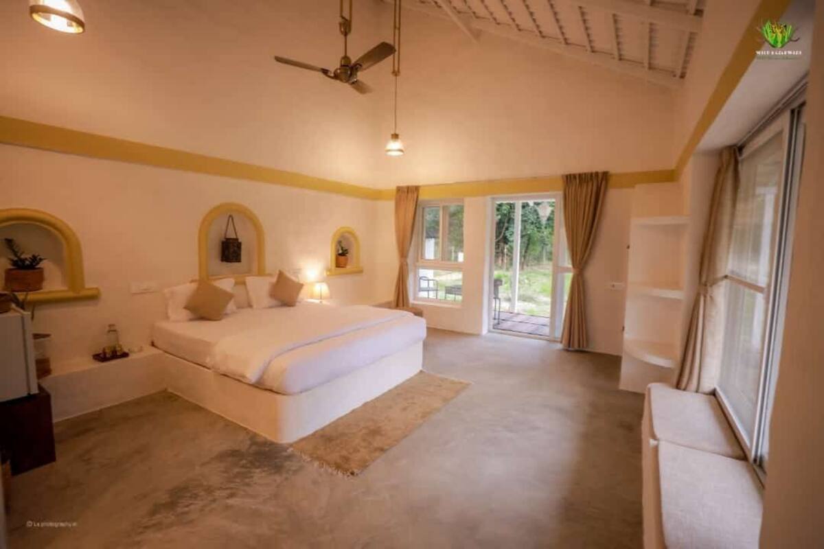 A bedroom with a bed, a ceiling fan, a window, and a view of the outdoors.