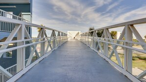 A pedestrian bridge with white railings and a concrete walkway. - Sunny Fort Walton Beach Condo - Walk to Ocean! (Fort Walton Beach)