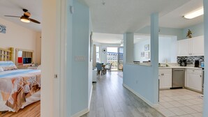 A spacious room with a bed, a ceiling fan, and a view of the balcony. - Sunny Fort Walton Beach Condo - Walk to Ocean! (Fort Walton Beach)
