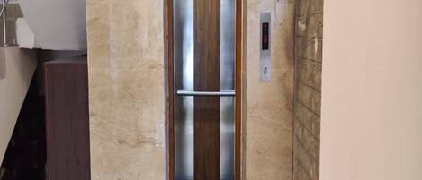 Un ascensor con interior metálico y puerta de madera.