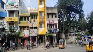 Calle con diversos comercios, entre ellos un estudio de yoga y una tienda de teléfonos móviles.