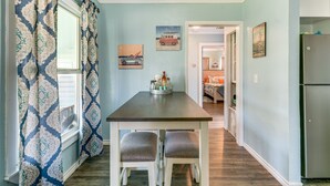 A dining area with a table and two chairs, a window with patterned curtains, and a refrigerator. - 2 Mi to Redfish Bay: Aransas Pass Home w/ Fire Pit (Aransas Pass)