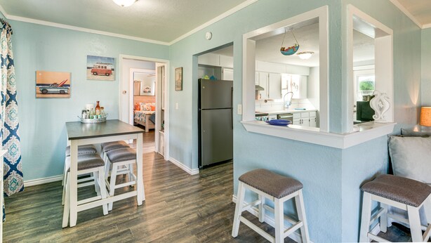 A kitchen with a refrigerator, a dining table with stools, and a bar area with stools. - 2 Mi to Redfish Bay: Aransas Pass Home w/ Fire Pit (Aransas Pass)
