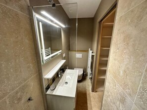 Een haardroger, handdoeken, zeep, toiletpapier