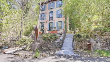 Un immeuble à plusieurs étages, avec un escalier en pierre menant à l’entrée.