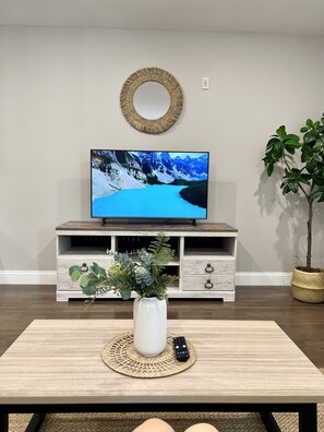 Relax in this stylish living room with a flat-screen TV, coffee table, and comfortable seating area.