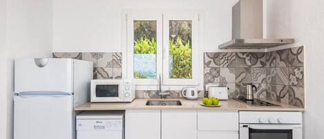 A modern kitchen with a dishwasher, microwave, stove, and oven.