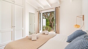 A bedroom with a bed, a view of the outdoors, and a wardrobe. - Menorca Sur T3, 3 bedroom (Torre Soli Nou)