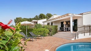 A poolside area with a tiled patio, outdoor seating, and a covered patio area. - Menorca Sur T3, 3 bedroom (Torre Soli Nou)