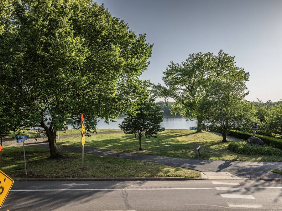 A road with a 2-6" sign, a pedestrian crossing, and a lake in the background.