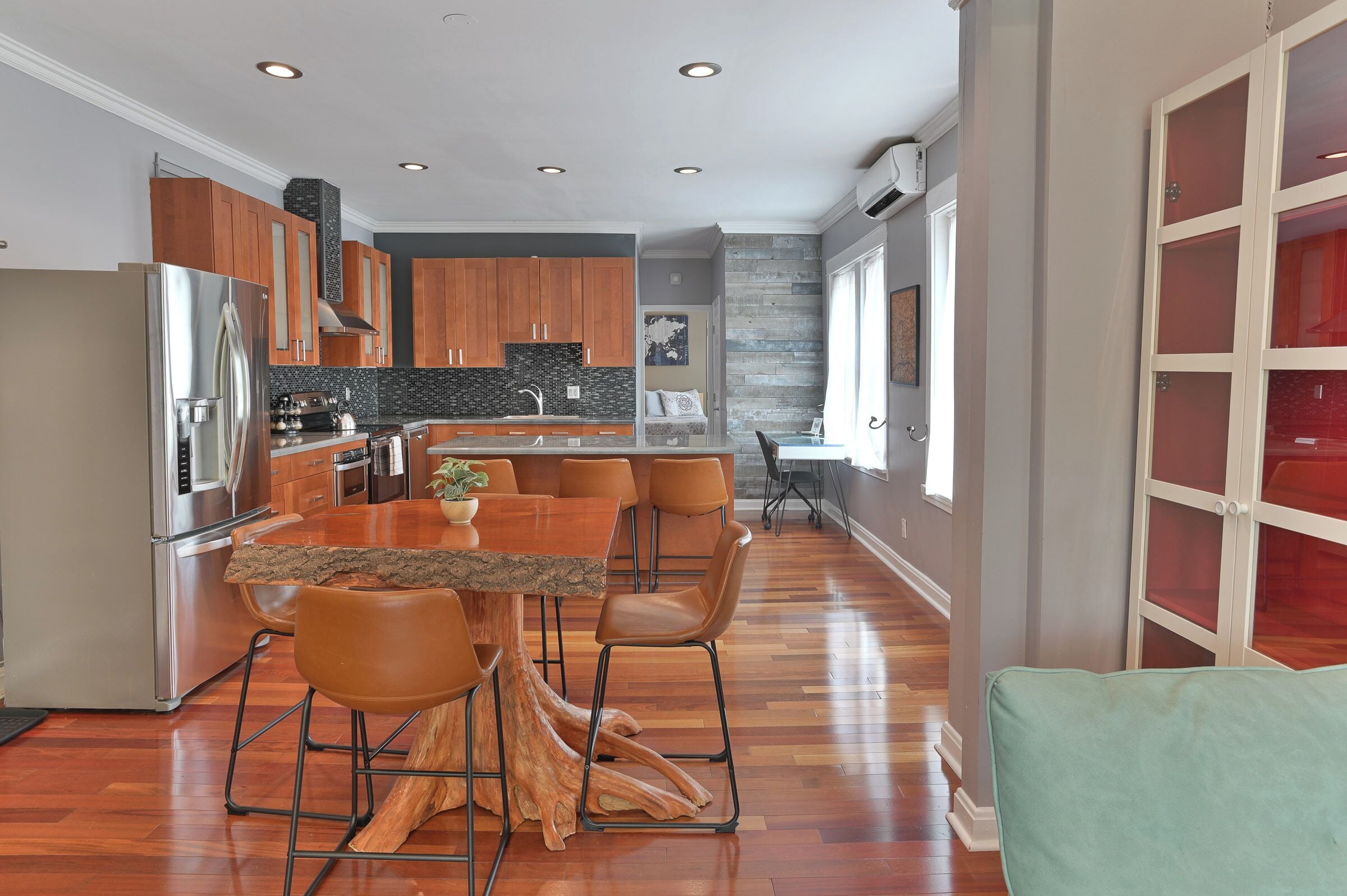 A modern kitchen with a central island, wooden cabinets, and stainless steel appliances.