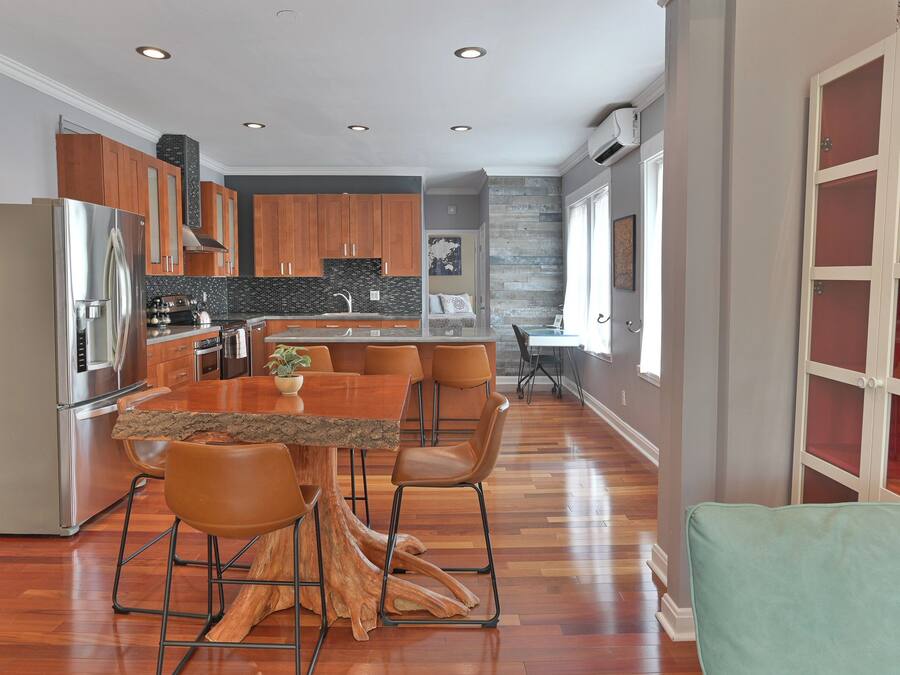 A modern kitchen with a central island, wooden cabinets, and stainless steel appliances.