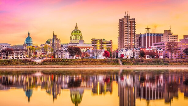 A cityscape with a prominent building with a green dome and a tall skyscraper.