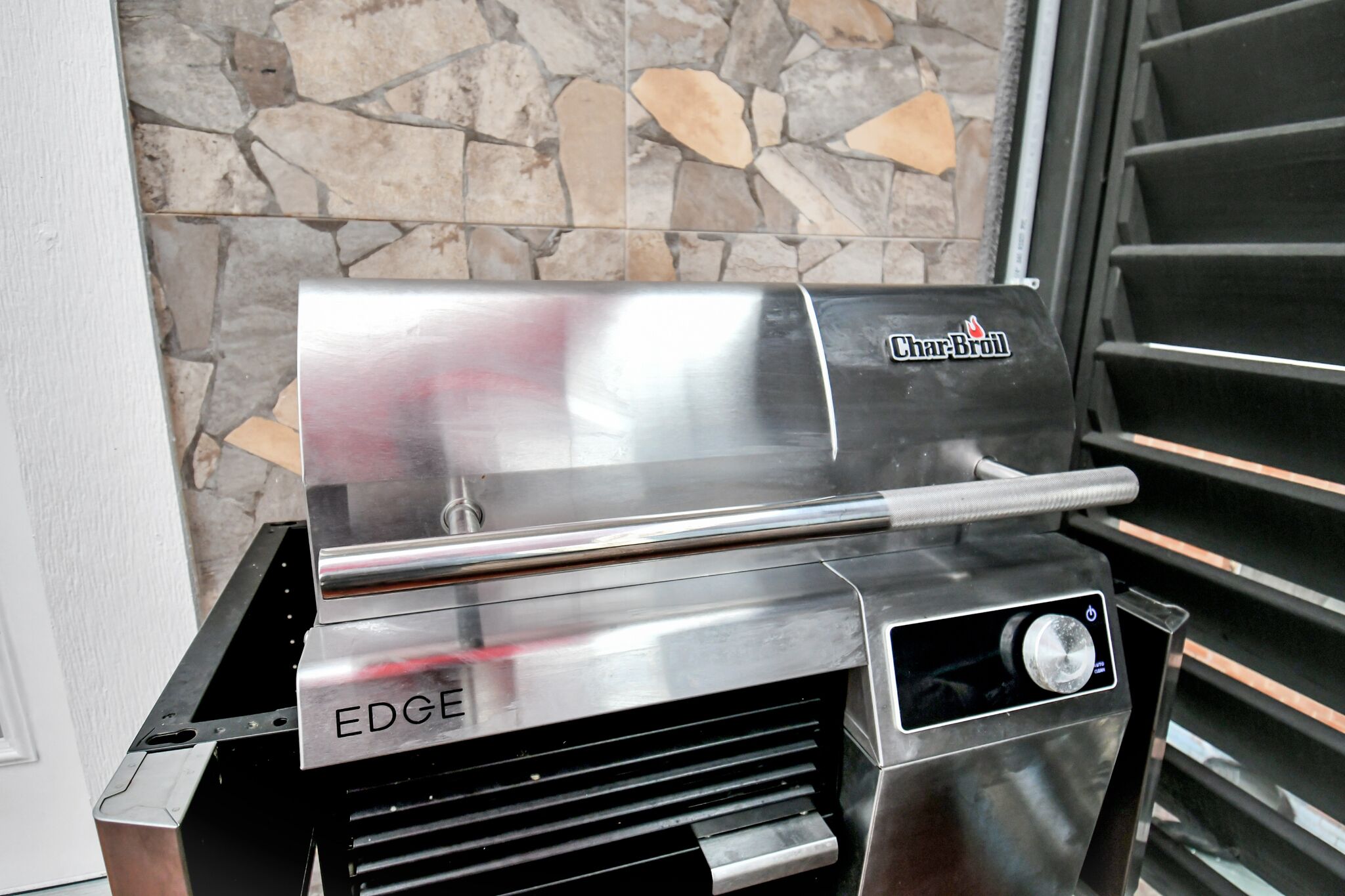 Ein Char-Broil EDGE Grill vor einer Steinsäule.