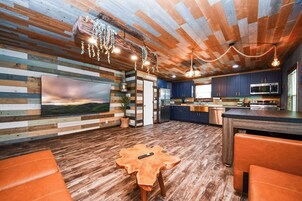 A modern kitchen with dark blue cabinets, stainless steel appliances, and a wooden island.