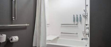 Uma casa de banho moderna com banheira, sanita e zona de duche.