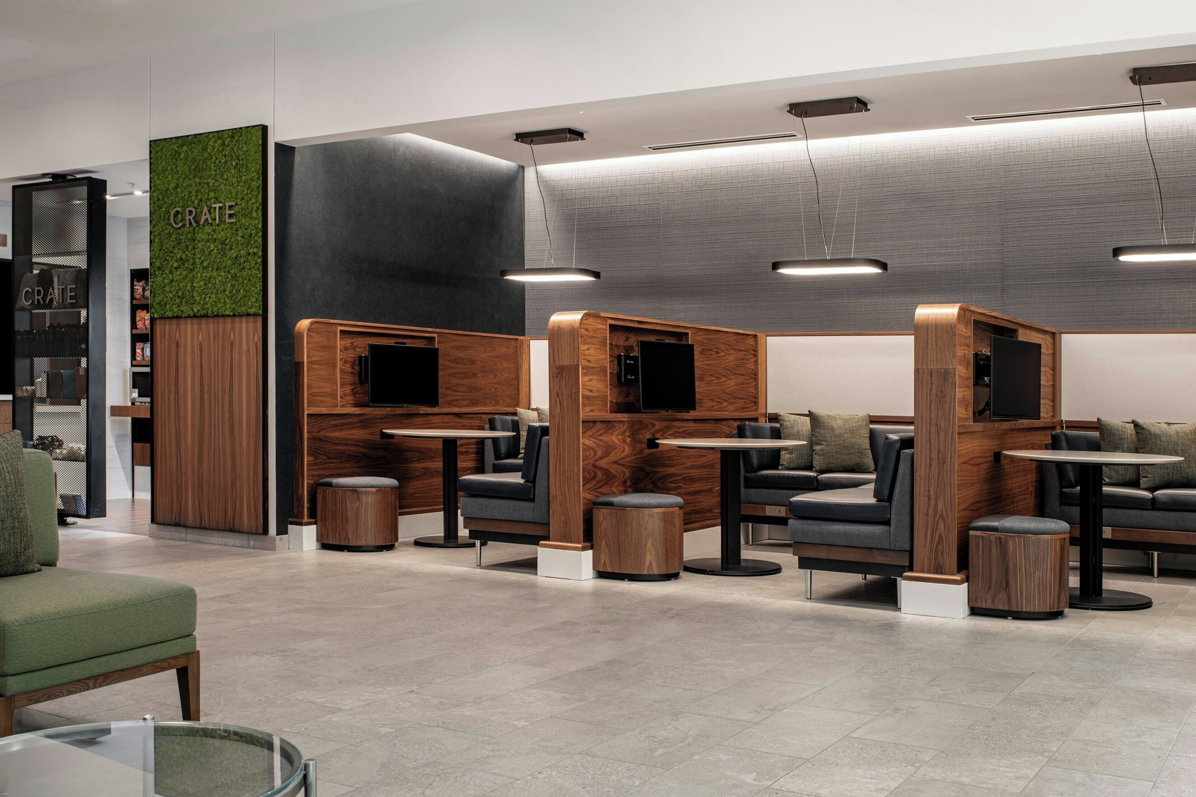 A modern cafe with wooden accents, comfortable seating, and a green wall with the word 'CRATE'.
