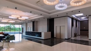 A modern hotel lobby with a reception desk, large windows, and decorative lighting. - Hotel Kapalai (Semporna)