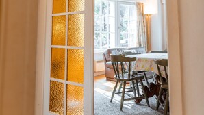 Una puerta con un panel de vidrio esmerilado que da a un comedor con una mesa y sillas.