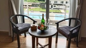 A room with a table set for two, a bottle, and a fruit bowl. - Hotel Orion (Sunwal)