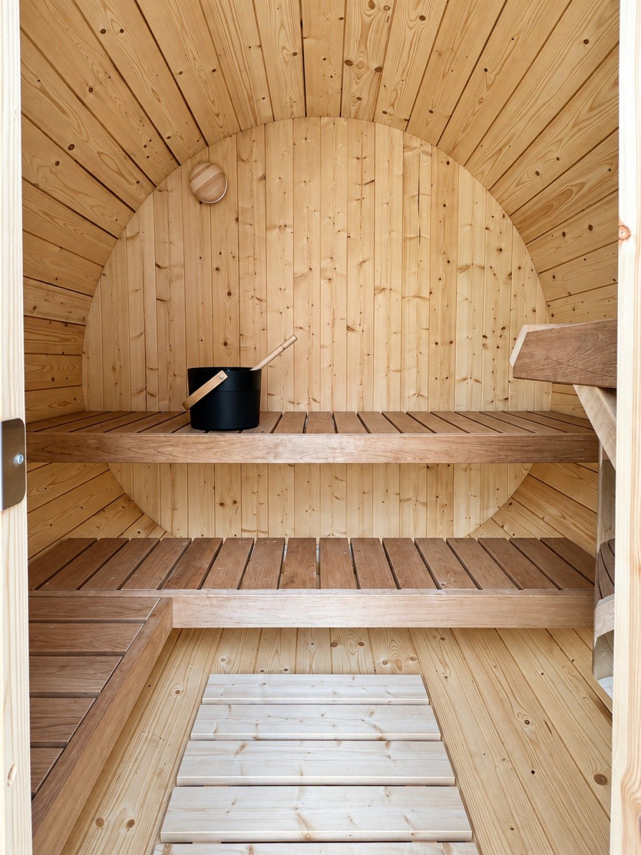 Un sauna avec des murs et des bancs en bois.