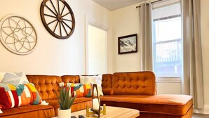 A living room with a brown sofa, a wooden coffee table, and a potted plant.