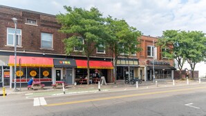 A street with brick buildings, outdoor seating, and bicycles.