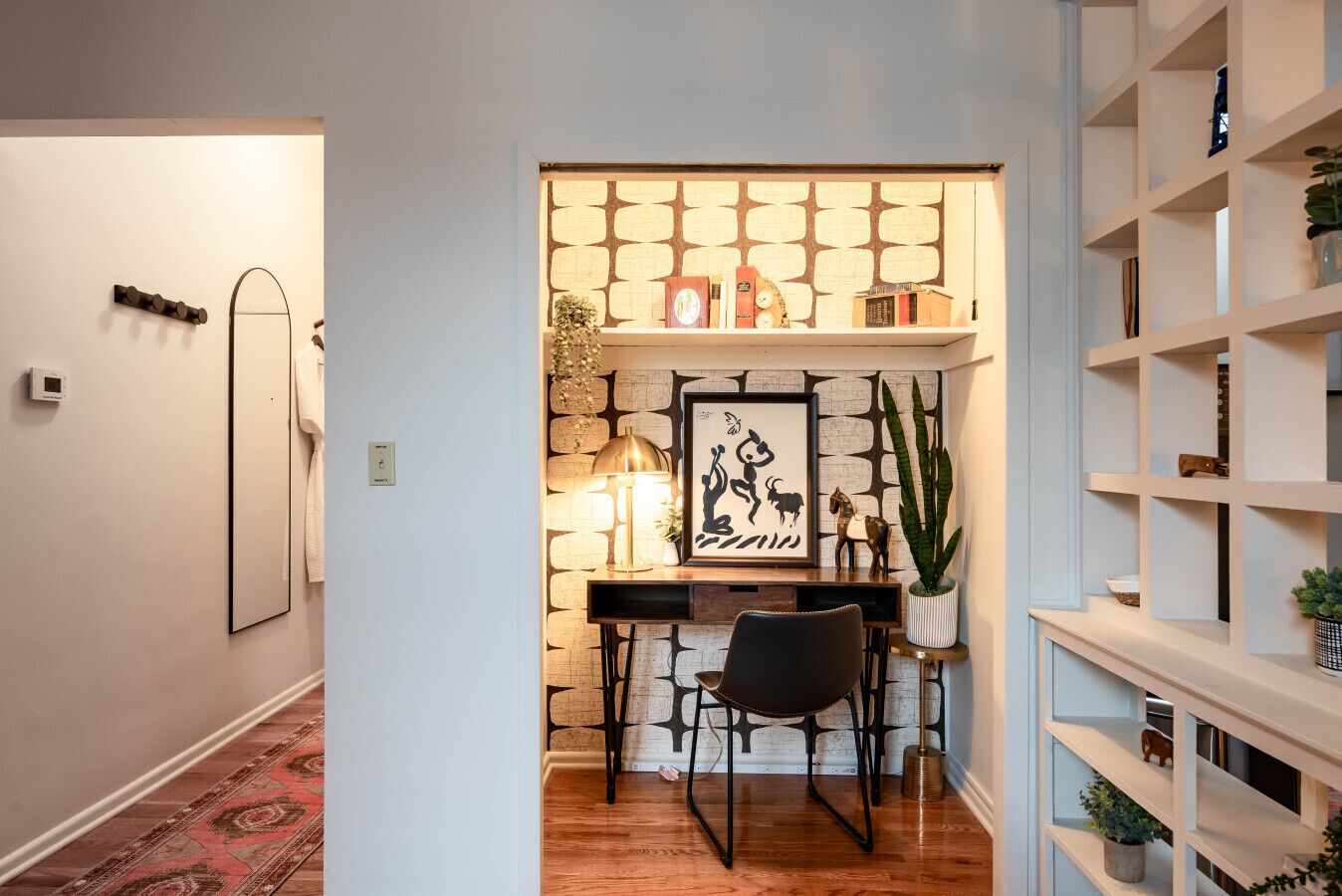 A cozy study area with a desk, chair, and shelves.