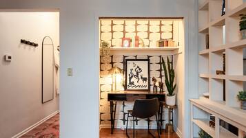 A cozy study area with a desk, chair, and shelves.