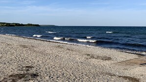 Ein Strand mit kiesigem Ufer und ruhiger Wellenbewegung.