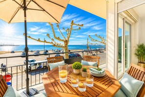 A balcony with a table set for two, a potted plant, and a view of the beach and city skyline. - CAL CATALA 1 Roses (Rosas / Roses)