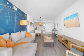 Un salon moderne avec un canapé, une table basse et une carte accrochée au mur.
