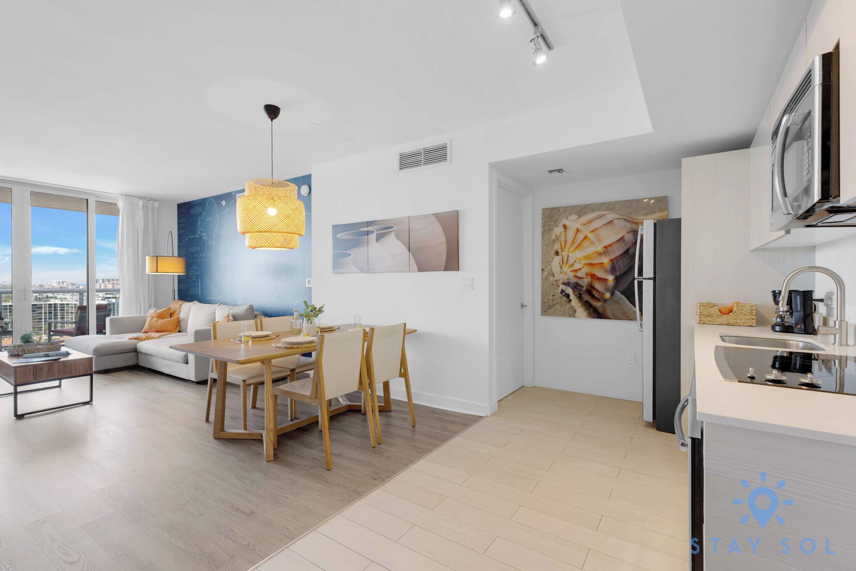 A modern apartment with a dining area, kitchen, and living room.