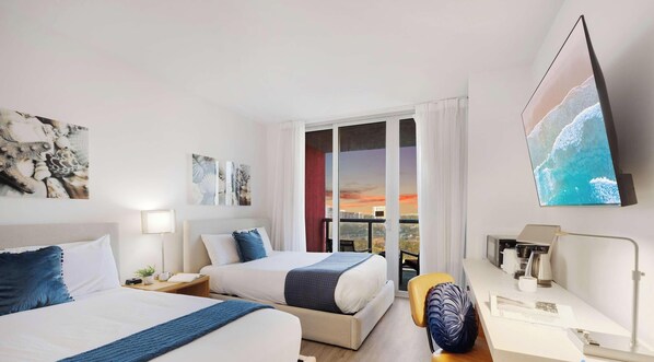 Camera d'albergo con due letti, una scrivania, una sedia, una TV e vista sulla città.